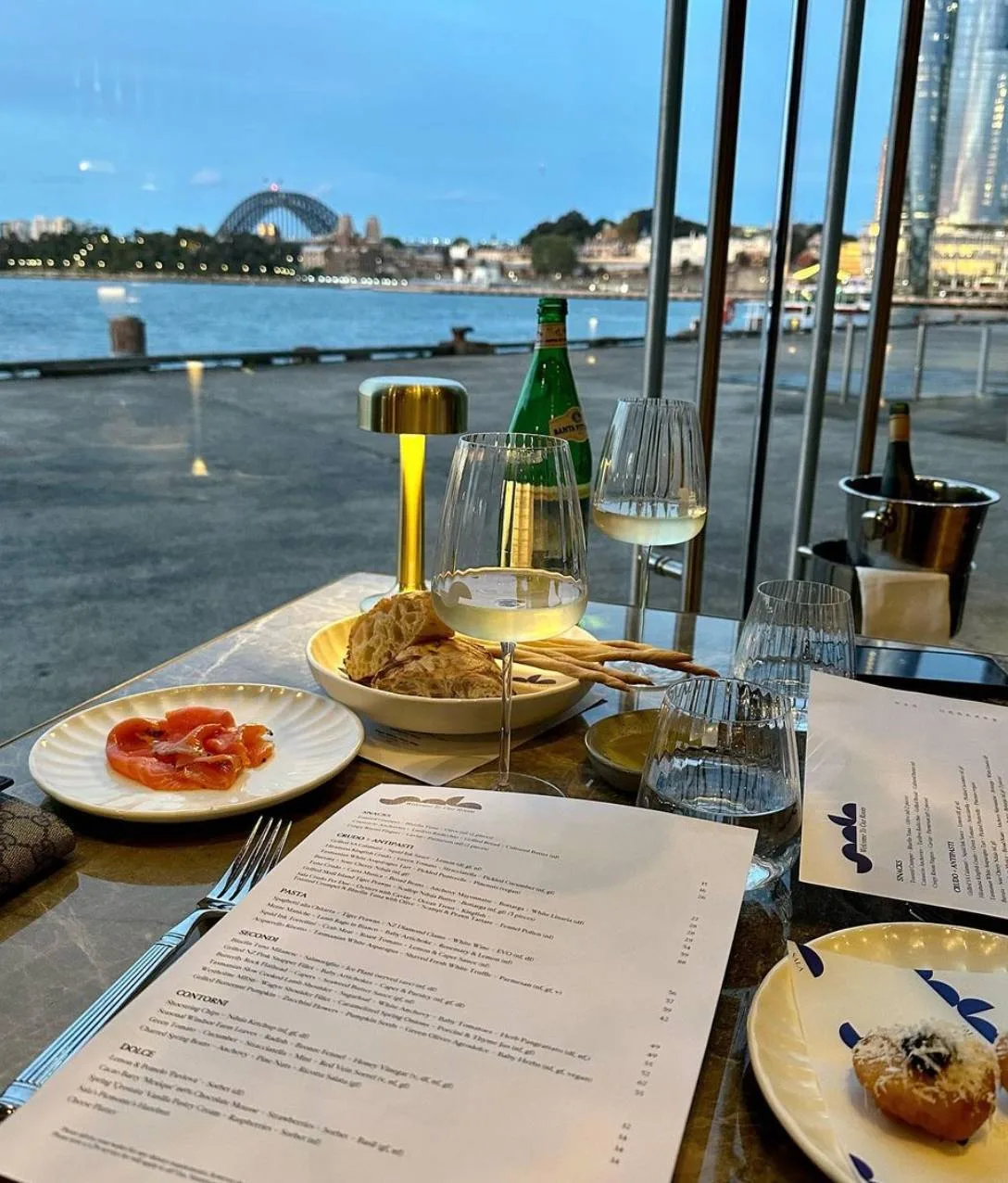 dining table with food & glass at waterfront restaurant Dining table set for a date at waterfront restaurant.